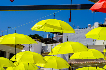 Colourful umbrellas urban street decoration. Hanging colorful umbrellas over blue sky, tourist attraction