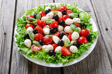 Salad with basil , tomatoes , olives and mozzarella