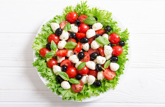 Salad with basil , tomatoes , olives and mozzarella