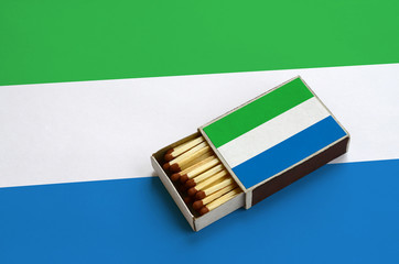 Sierra Leone flag  is shown in an open matchbox, which is filled with matches and lies on a large...