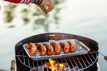 Grilled sausage on the flaming grill, close up