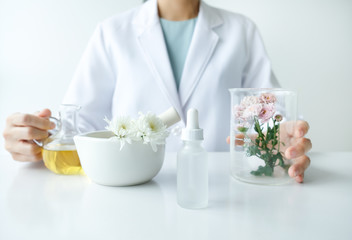 the scientist,dermatologist testing the organic natural product in the laboratory.research and development beauty skincare concept.blank package,bottle,container .cream,serum.
