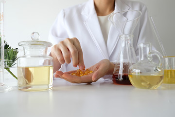 doctor woman scientist making herbal medicine in lab with herb leaves vitamin supplements mineral...