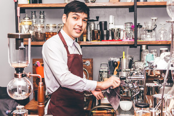 Man Barista using coffee machine for making coffee in the cafe