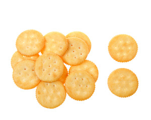 Round salted crackers randomly strewn on  white background isolated.