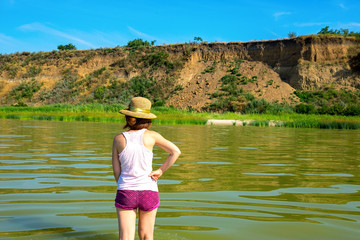 Rest on the Azov Sea. A girl in a hat walks along the coast of the sea. Girl looking at the sea.