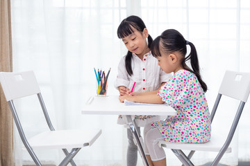Asian Little Chinese sisters doing homework