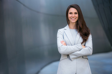 Cheerful successful business woman portrait at executive financial bank building, smiling with arms...