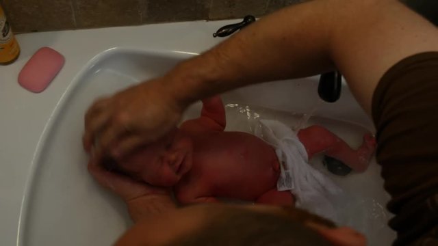 Baby takes first bath and crys.