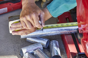 A Man's Hand marking where to cut steel pipe