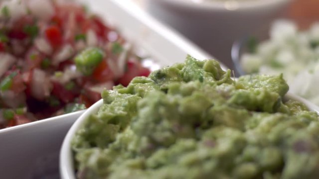 Tracking shot over chip dipping into guacamole