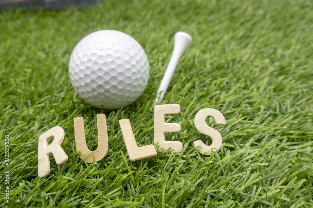 Wall mural rules of golf with golf ball and wording rules are on green grass