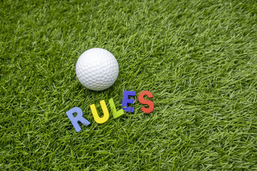 Rules of golf with golf ball and wording rules are on green grass