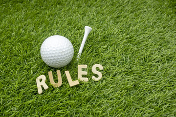 Rules of golf with golf ball and wording rules are on green grass