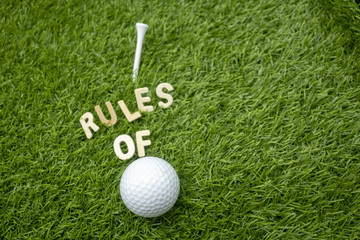Rules of golf with golf ball and wording rules are on green grass