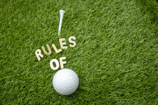 Rules of golf with golf ball and wording rules are on green grass