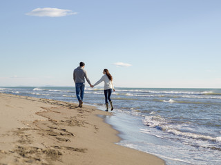 Loving young couple on a beach at autumn sunny day