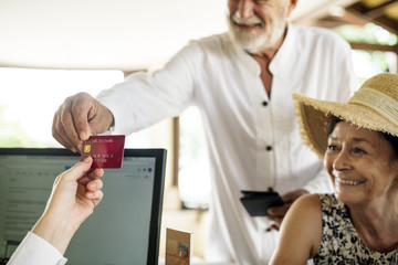 Old man giving credit card to receptionist