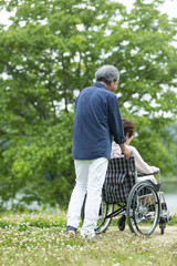 Obraz premium 車いすで散歩する老夫婦