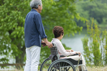 車いすで散歩する老夫婦