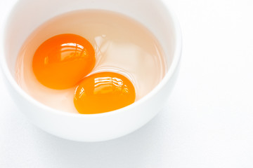 Raw egg yolks in white bowl