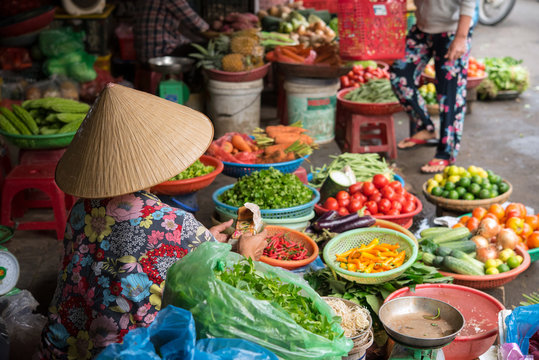 Vietnamese woman selling vegetables at market in Hoi An　ベトナム・ホイアンの市場で野菜を売る女性