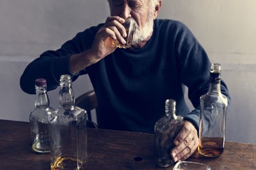 Elderly man sitting drinking whiskey alcoholic addiction bad habit