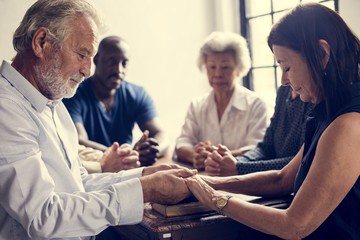 Group of people holding hands praying worship believe