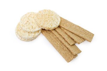 Flat rye and puffed rice crispbreads on a white background