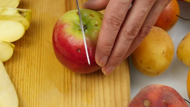 housewife at home preparing fresh salad slicing apple fruits on cutting board. vegetarian healthy food and dieting concept. slow motion