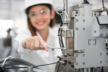 Female industrial engineer wearing hard hat work at factory.