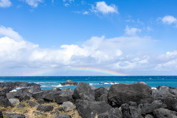 Fototapeta na wymiar Rainbow over the Indian Ocean from the Gulf of Etang Sale in Reunion Island
