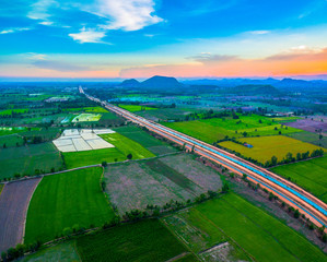 Naklejka premium aerial view scenery sunset on new route pass in the rice field. under construction new motorway connect to Myanmar.