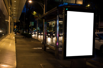 Blank white mockup in bus stop at night