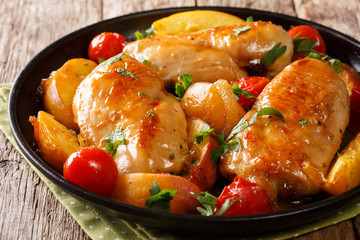 baked chicken breast with peaches, tomatoes, onions closeup on a plate on a table. horizontal