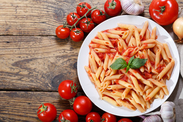plate of pasta with tomato sauce on wooden table