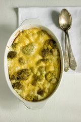 Casserole with broccoli, cauliflower and cheese on a light background.