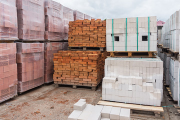 White and red bricks folded on pallets