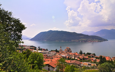 Fototapeta na wymiar Monte Isola island inside Iseo Lake, green hill covered by forests, surrounded by water, sunny summer day