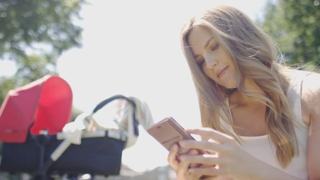 Young woman on her phone outdoors in a park, in slow motion