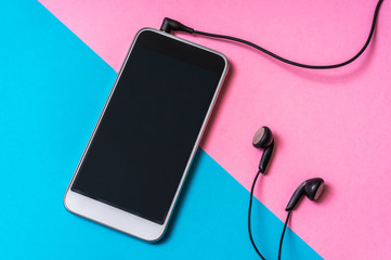 Mobile phone with headphones isolated on colorful background