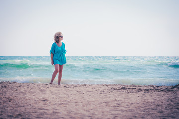 Fototapeta na wymiar Middle-aged woman female enjoying sunny day on tropical beach