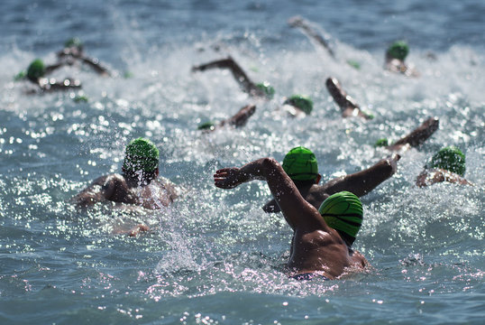 Group people in wetsuit swimming, participants of swimming race