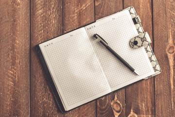 notebook with pen on old wooden table