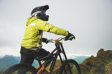 Portrait of a man aged on a mountain bike in the mountains in cloudy weather. Mountain bike concept