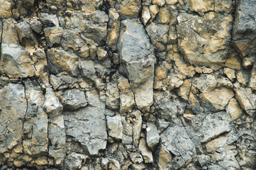Pebble stones in a rocky wall. Natural background of a rocky stone wall