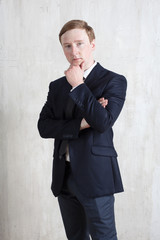 Businessman in a business suit on the background of a light wall. Business. Emotions. Psychology