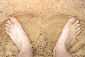 Feet resting on the beach men. Toned, glow