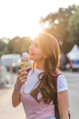 Fototapeta premium side view of smiling young woman eating ice cream