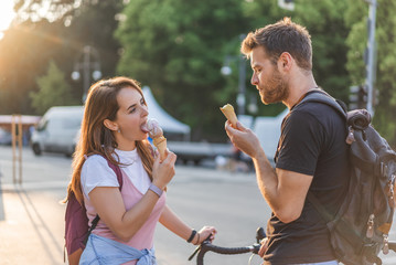 Fototapeta premium selective focus of young couple with backpacks eating ice cream